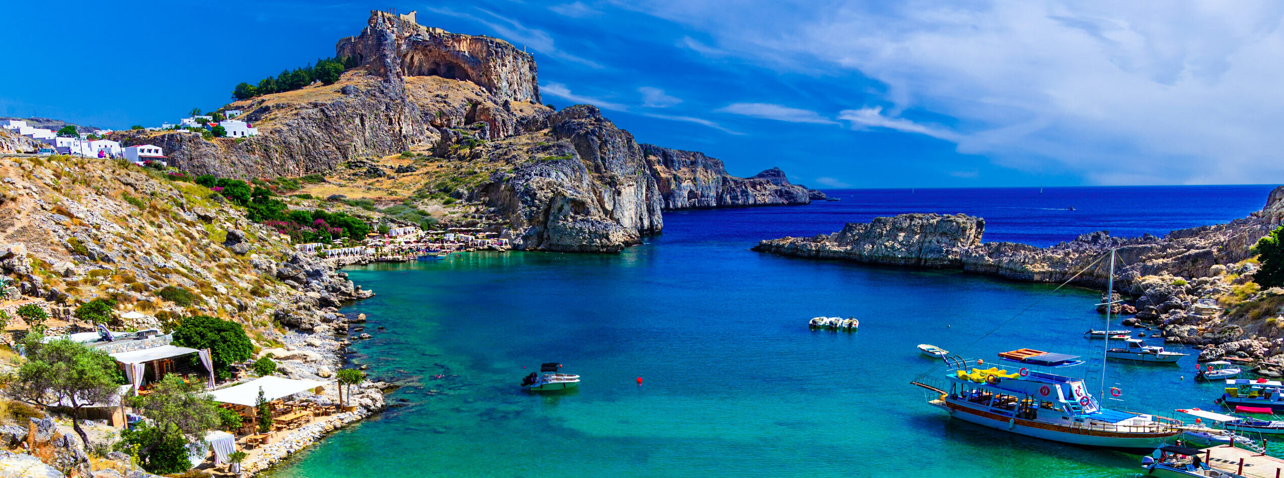 Lindos city on Rhodes island, Greece. St Paul's Bay Beach and the Acropolis, on Rhodos Island, Greece at Aegean Sea
